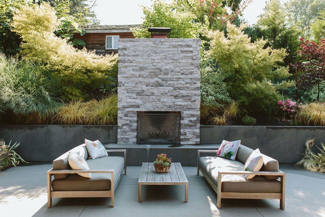 Outdoor fire place and living area with a retaining wall and lush plantings - by Dennis' 7 Dees Outdoor fire place and living area with retaining wall and lush plantings beyond - by Dennis' 7 Dees