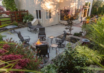 Patio with firepit, patio furniture, and plants by Dennis' 7 Dees Landcsaping