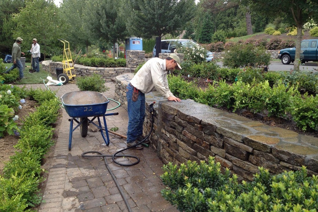 Cottage garden walls and beds in progress - 7 Dees Landscaping Crews install plants in a retaining wall planter bed as a landscape is built - 7 Dees Landscaping