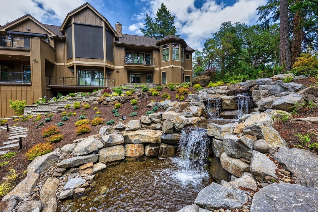 Natural stone waterfall water feature designed on a sloped landscape by Dennis' 7 Dees Natural stone waterfall water feature designed on a sloped landscape by Dennis' 7 Dees