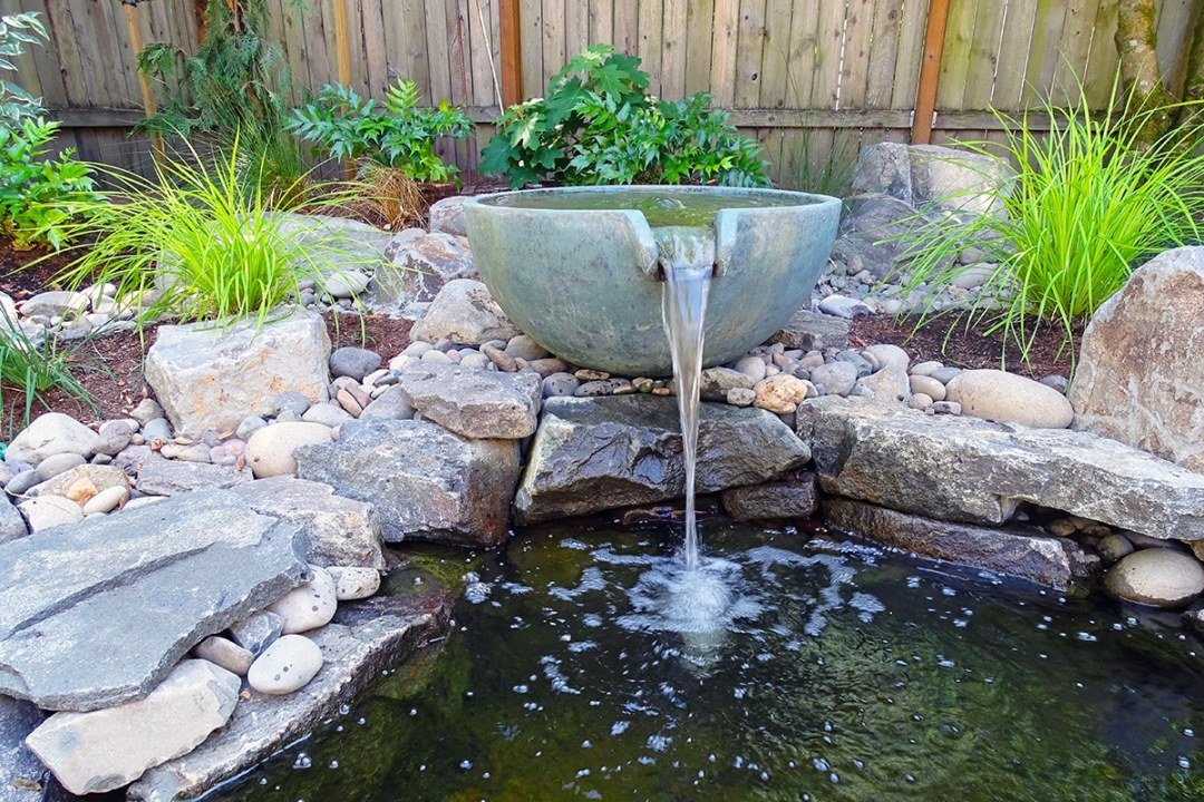 Water feature with bowl and pond - 7 Dees Landscaping Water feature with large bowl pouring into small rock-lined pond - 7 Dees Landscaping