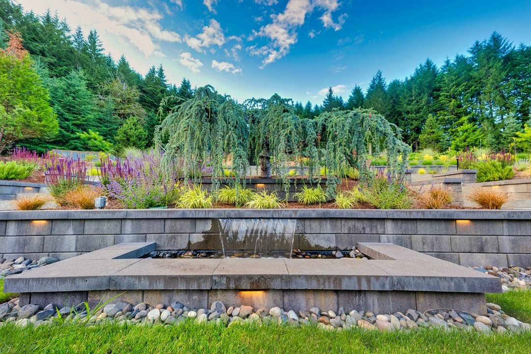 Water Feature in Retaining Wall - 7 Dees Landscaping Water feature pours into square pond in sharp-edged retaining wall - 7 Dees Landscaping